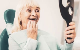 Excited older woman amazed by her new denture alternatives