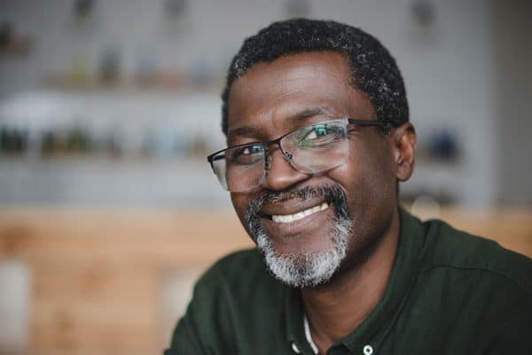 happy man with large eye glasses shows off his confident smile